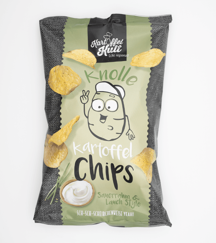 Bunte Kartoffelchips in einer grünen und schwarzen Verpackung mit Cartoon-Kartoffel, die eine Peace-Geste zeigt, und einem Dip.