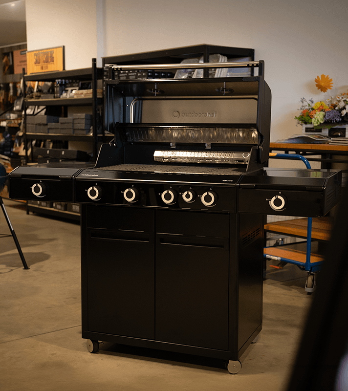 Outdoorchef HEAT 445 Gasgrill mit geöffneter Grillhaube und sichtbarer Grillfläche in Schwarz