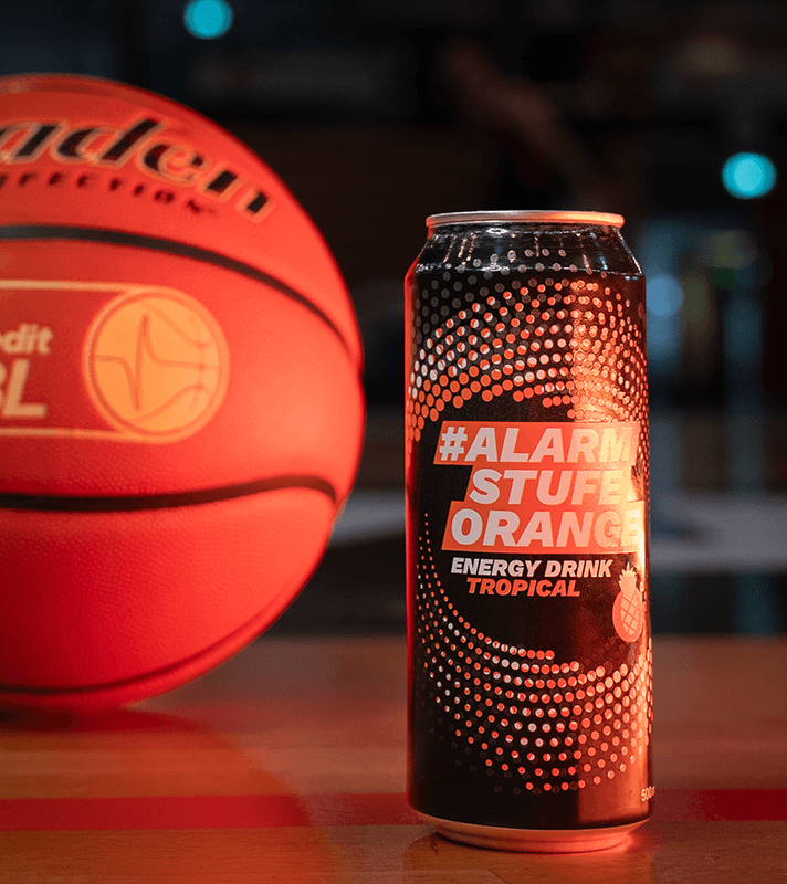 Energy Drink mit Schrift Alarmstufe Orange und Basketball im Hintergrund